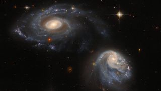 two spiral galaxies against starry background