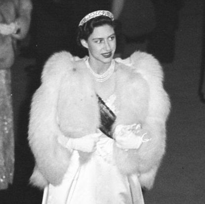 Princess Margaret wearin ga white fur wrap and white satin dress with a tiara in 1948