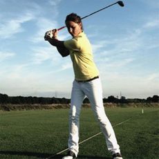 woman swinging golf club