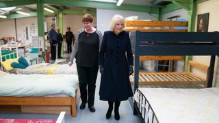Camilla, Queen Consort is given a tour by the Head of Business Rachael Burton during a visit to The Emmaus Community at Bobby Vincent House in West Norwood on December 13, 2022 in London, England. The Queen Consort visited the charity to hear about their efforts to develop a women-only provision for those experiencing homelessness