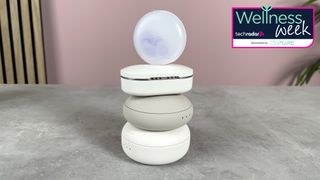 The Loop Dream earplugs case is balanced on top of a stack of other earplugs that have been tested.