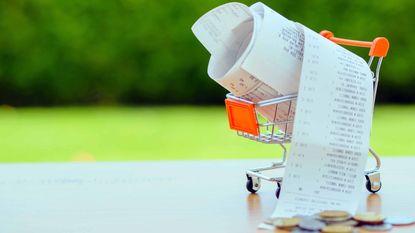 inflation as seen through a tiny grocery cart with a receipt pouring out the side