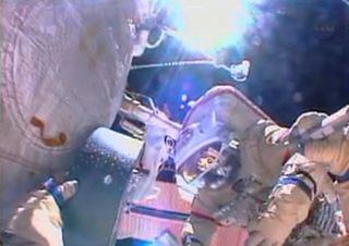 Russian cosmonaut Alexander Misurkin works outside the International Space Station, with the Earth far below, in this still from a NASA broadcast on Aug. 16, 2013.