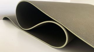 Image shows a side view of an unrolled Sweaty Betty Super Grip Yoga Mat.