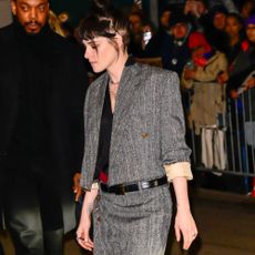 Kristen Stewart wears a grey two piece with red two-tone cone heel shoes.