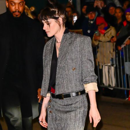 Kristen Stewart wears a grey two piece with red two-tone cone heel shoes.