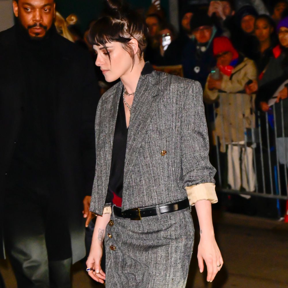 Kristen Stewart wears a grey two piece with red two-tone cone heel shoes.