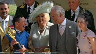 jockey Frankie Dettori (2L) shares a joke with Britain's King Charles III (2R) as he celebrates with the Gold Cup trophy on the third day of the Royal Ascot