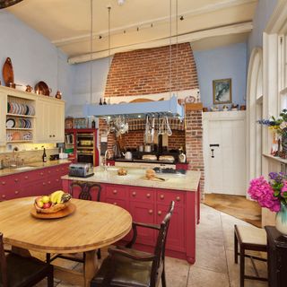 kitchen with red cabinet blue wall and table with chairs