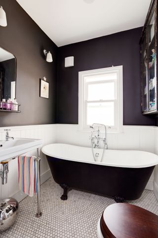 bathroom with dark interior scheme, white panels and large freestanding bath photographed by Bruce Hemming