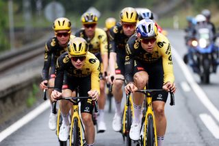 Jonas Vingegaard and Wout Van Aert cycling in the rain in a group