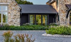 a home with a flower bed outside with natural plants