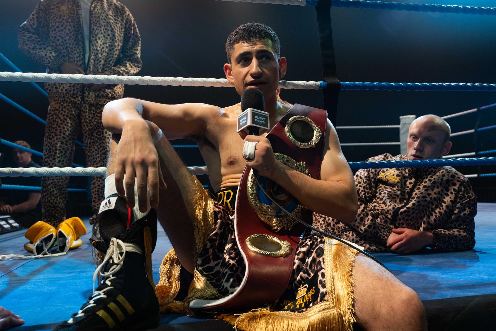 an image of amir el-masry as Naz Hamed giving an interview after one of his biggest fights, sitting ring side