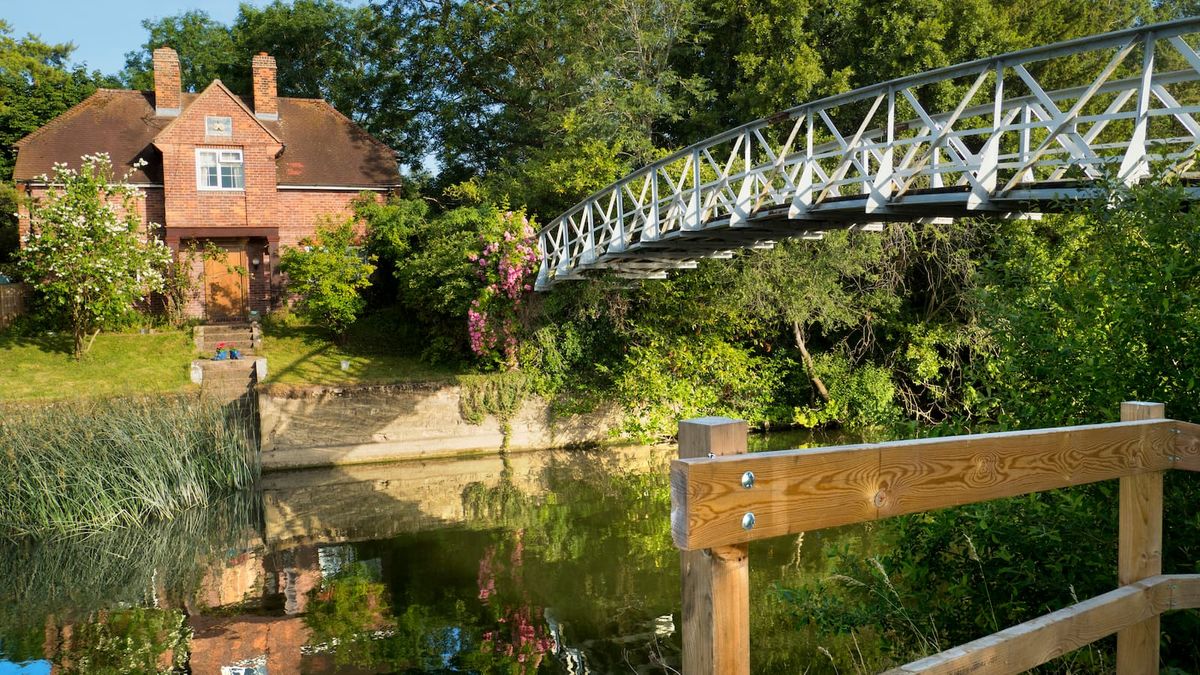 Idyllic cottage next to a bridge in the River Thames