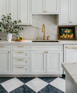 white neutral shaker kitchen with nblack and white checkerboard marble floor