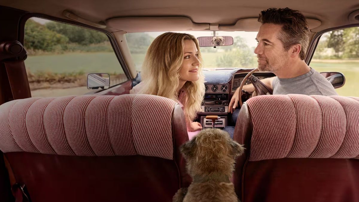 Harriet Dyer as Ashley and Patrick Brammall as Gordon in the front seats of a car with Colin the dog in the backseat looking at them through the rear view mirror