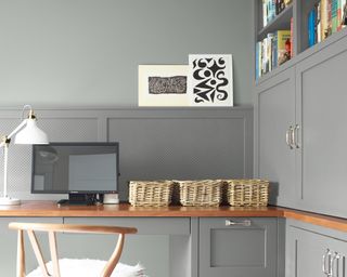 Home office set-up with gray walls and cabinets.