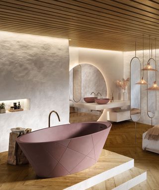 Large, luxury bathroom with wooden paneling ceiling and lighting, textured white painted walls, oval shape bath on top of tiered wooden platform, large rounded mirror and two oval mirrors, collection of pendants