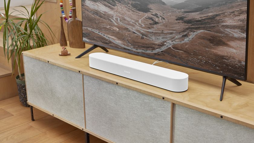 Sonos Beam Gen 2 in white on a modern wooden media unit sitting below a TV