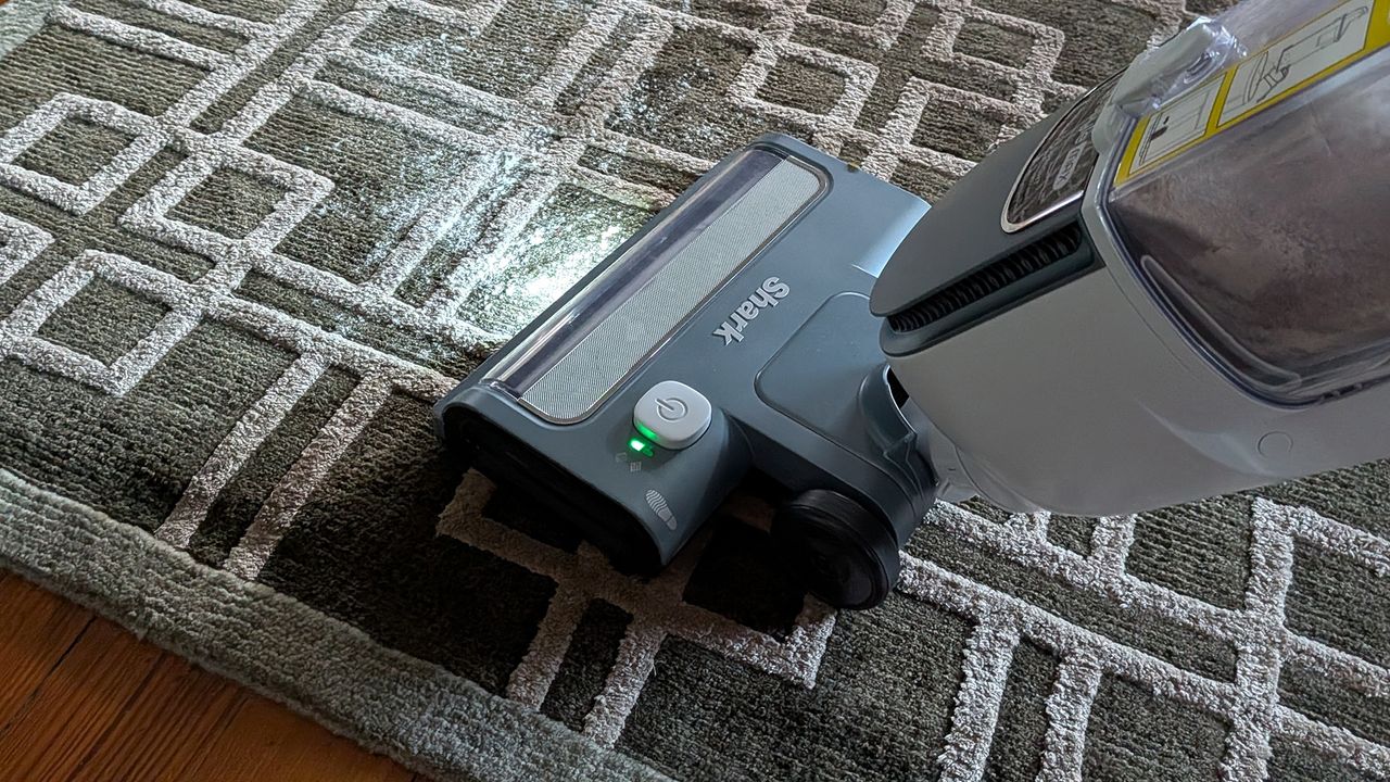 Tester using the Shark Freestyle Max cordless upright vacuum to clear flour from a carpet rug