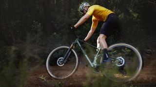 A man riding the Berria Mako cross-country bike through a forest