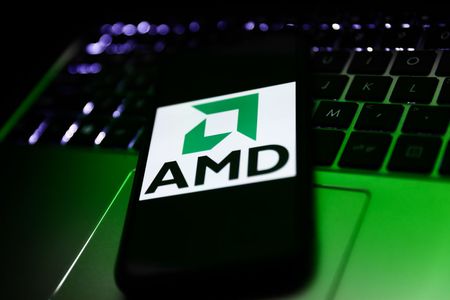 Advanced Micro Devices, or AMD, logo on smartphone screen with laptop in background