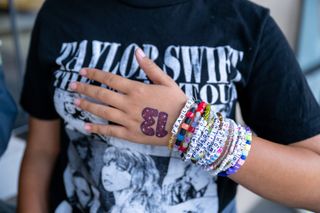 A Taylor Swift fan, friendship bracelet detail, attends the opening night theatrical release of "Taylor Swift : The Eras Tour."