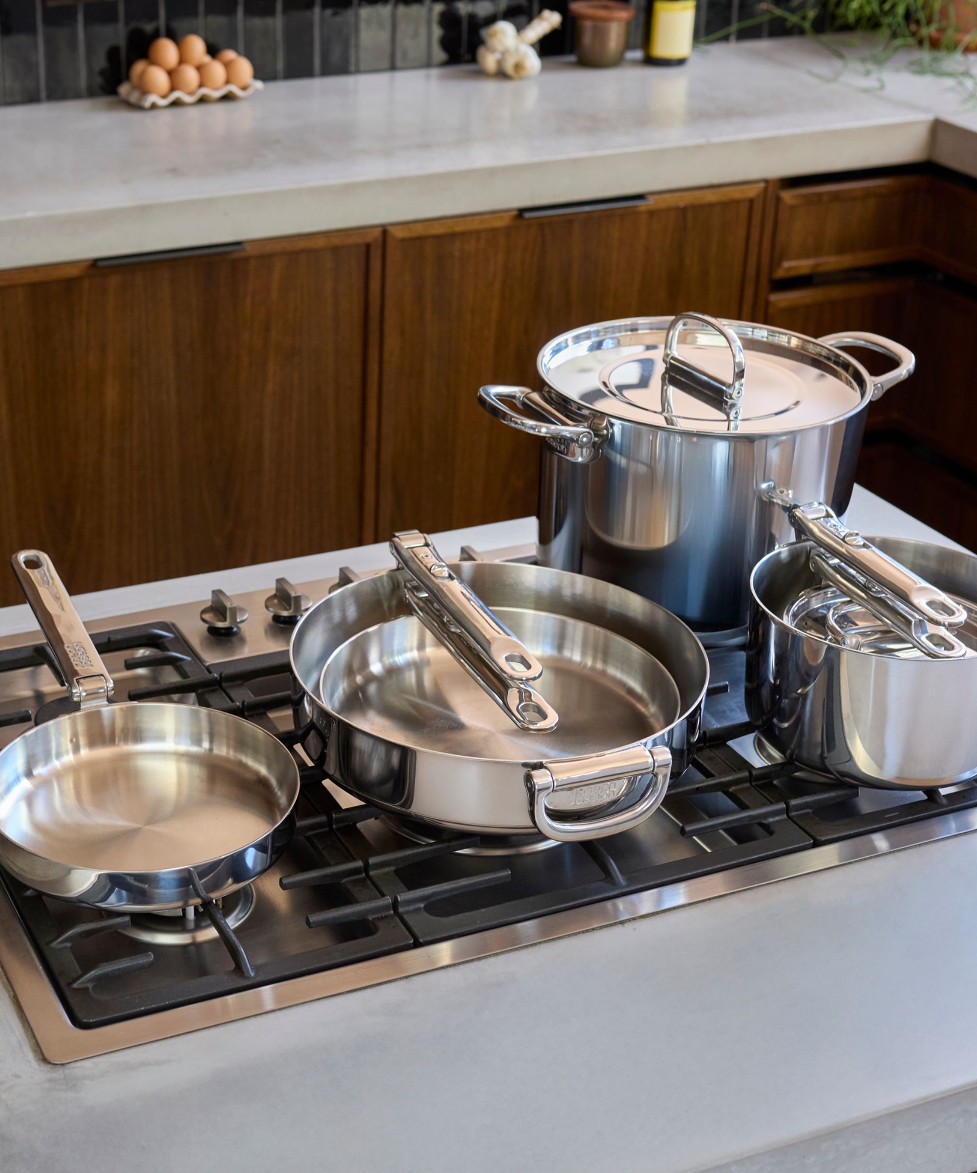 Two stainless steel frying pans and two stainless steel saucepans with folding handles