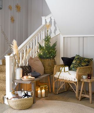Alternative Christmas tree ideas with a miniature Christmas tree and Scandi-style seating area built around it in a stairwell