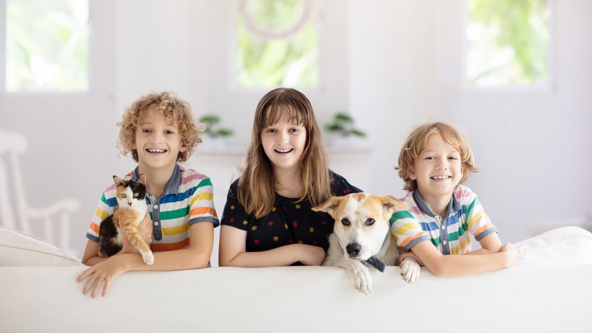 Three children with their pet dog and cat