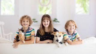 Three children with their pet dog and cat