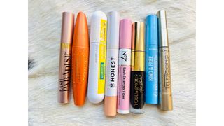 Eight of the best drugstore mascaras laying on a white fur background