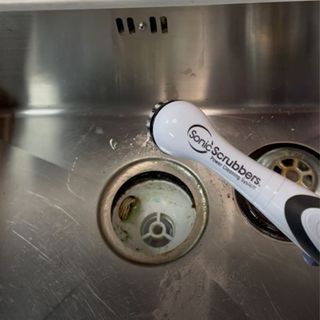 Cleaning kitchen sink plughole with SonicScrubber electric brush