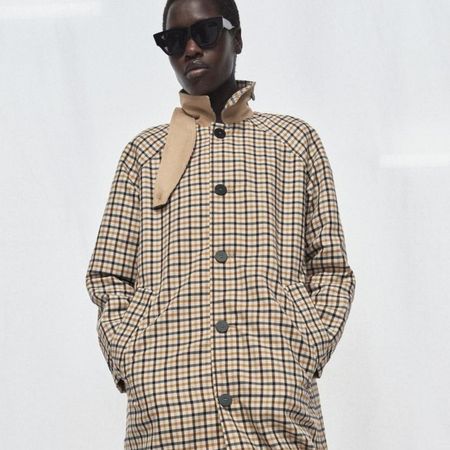 Model wears a reversible check trench coat from Zara