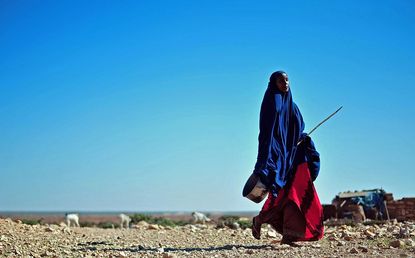 A woman walks through drought conditions in Somalia