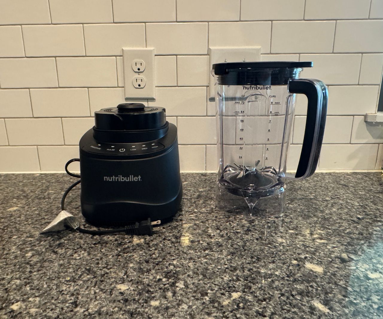 The nutribullet PowerCore XL Blender in two parts - the black motor base and the clear pitcher, on a stone kitchen counter against a white tile backsplash