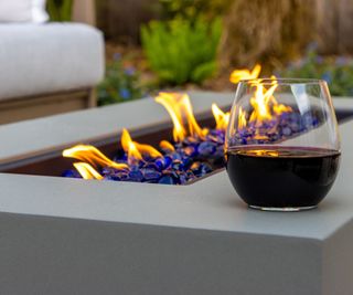 Closeup on fire table with a stemless glass of wine