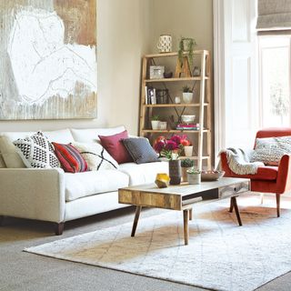 neutral living room with white sofa and red armchair