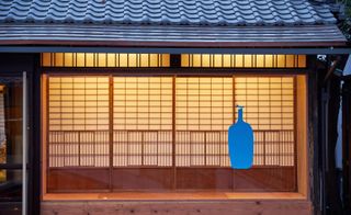 The blue logo and exterior wall of Blue Bottle Coffee in Kyoto, Japan