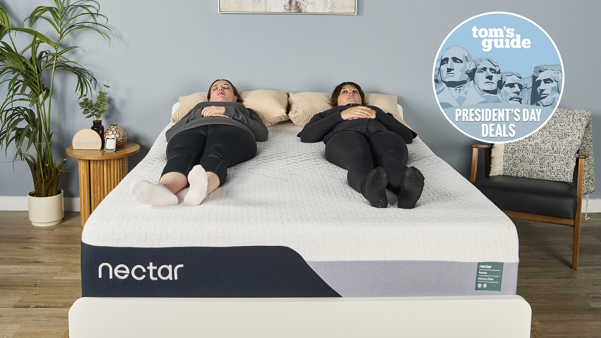 Two mattress testers lie on their backs on the Nectar Premier Memory Foam mattress on a bed frame in our Sleep Lab. In the top right corner is a Tom's Guide Presidents' Day deals graphic