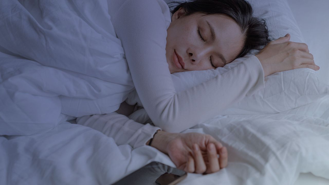 A woman sleeping near her phone