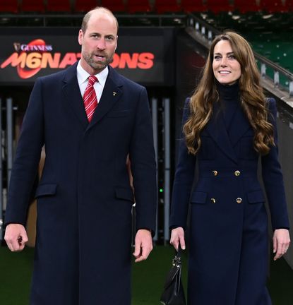 Kate Middleton and Prince William walking on to a rugby pitch smiling in March 2025