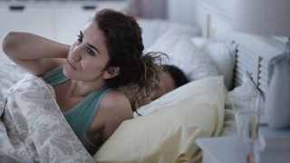 How often should you change your mattress: a woman wakes up with a stiff neck after sleeping on a mattress that doesn't support her sleep position