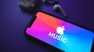 Apples musikk-app sammen med noen ørepropper på en mørk bakgrunn.