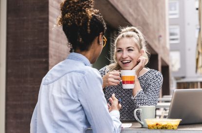 two women sat outside with hot drinks after lockdown ends