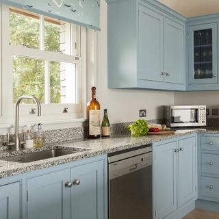 Kitchen with blue cabinets and silver dishwasher