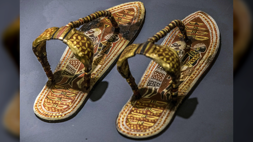 a pair of decorated wood-and-leather sandals on a grayish table