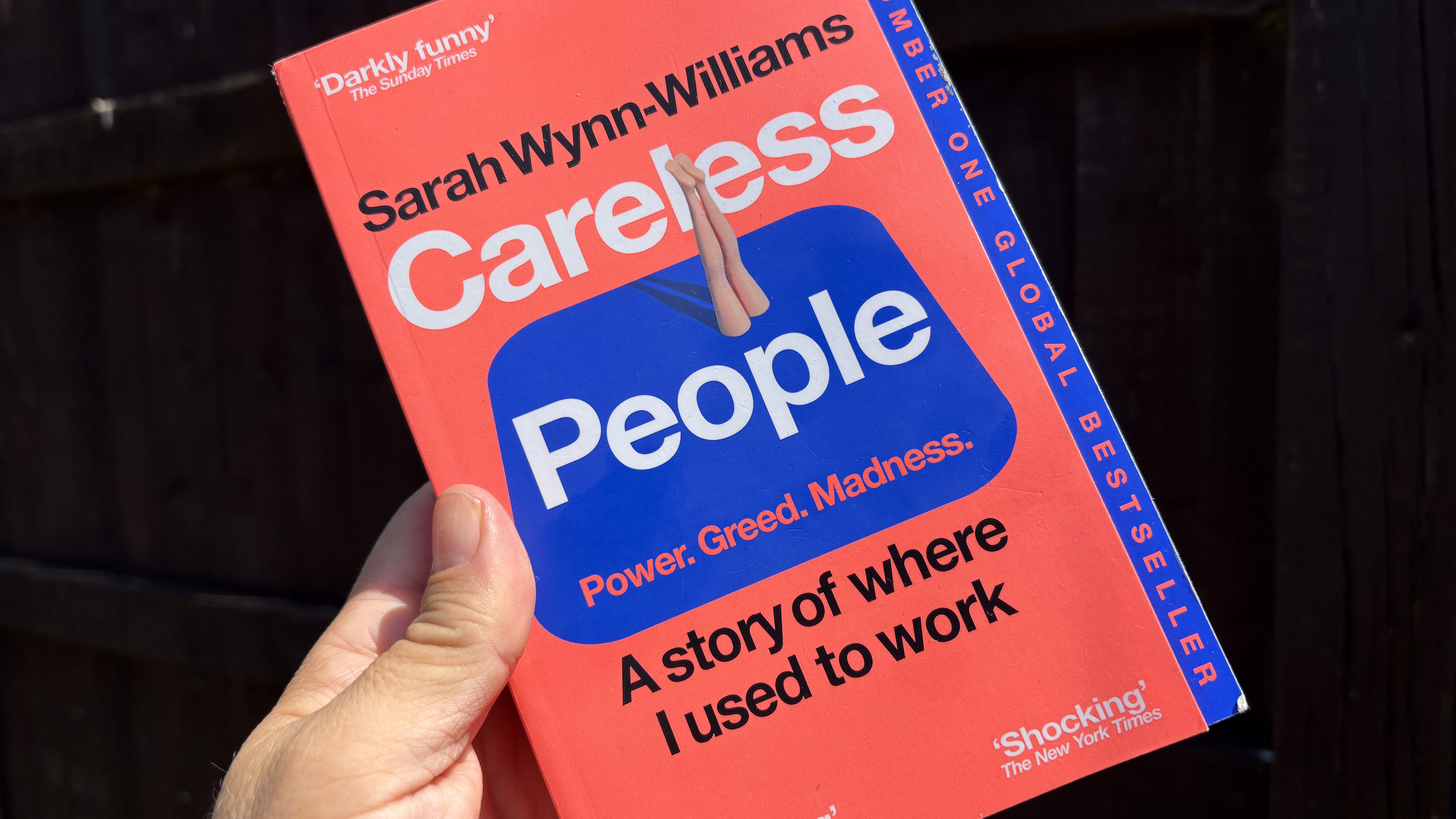 The book Careless People being held in a hand.