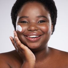 best moisturiser for dry skin - woman with face cream on her cheek smiling - getty images 1680079842