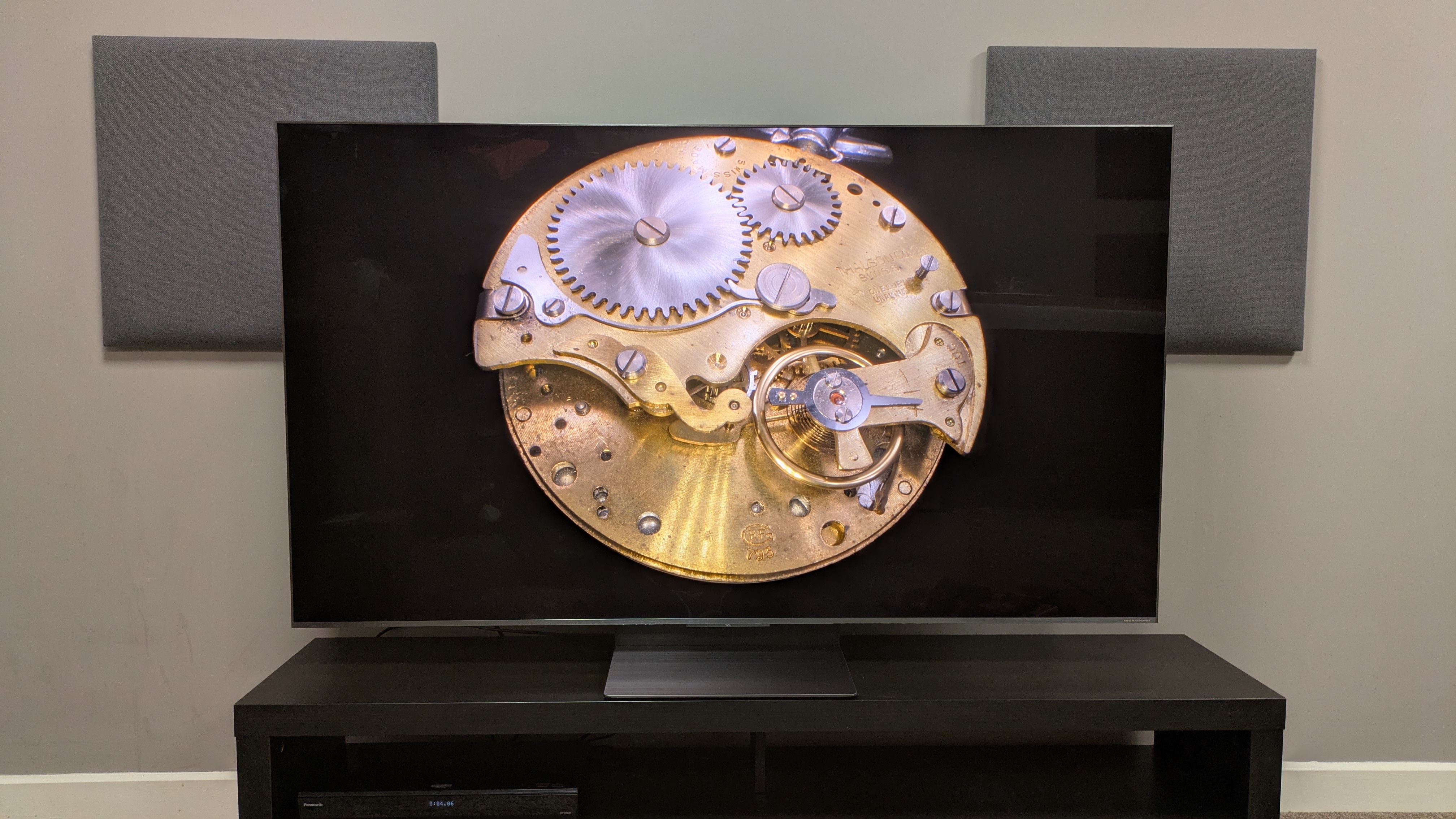 TCL C8K with pocket watch against black background on screen